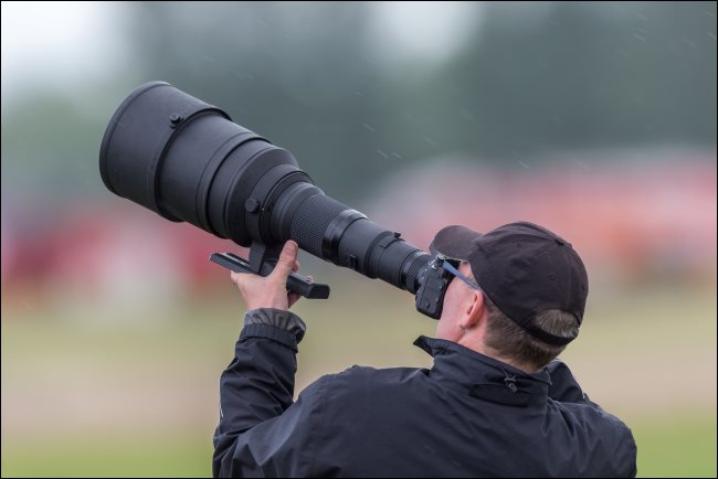 Un fotógrafo que usa un teleobjetivo enorme.