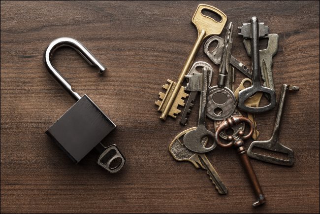 Plusieurs clés à côté d'un cadenas ouvert.
