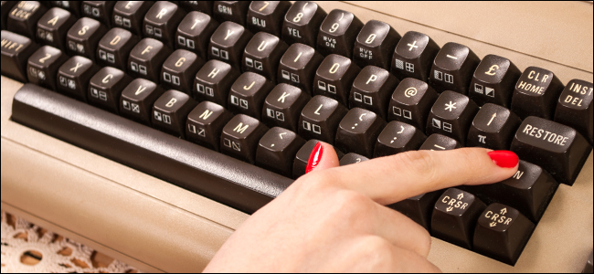 Una donna che scrive su una vecchia tastiera.