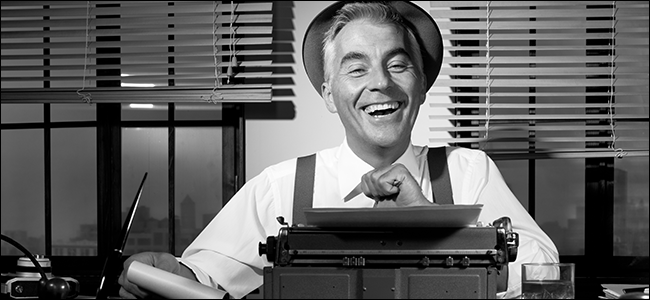 Un ancien journaliste rit derrière une machine à écrire.