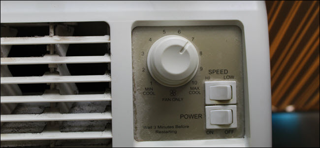Primer plano de la unidad de aire acondicionado que muestra interruptores mecánicos de potencia y velocidad y un dial giratorio.