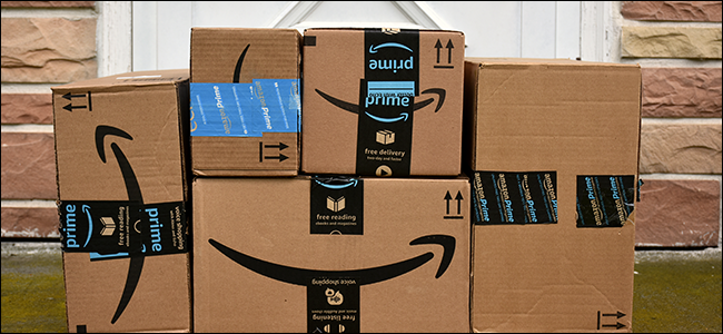 Una pila di scatole di Amazon davanti a un portico.