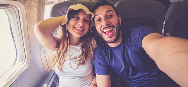 Una joven pareja tomando un selfie en un avión