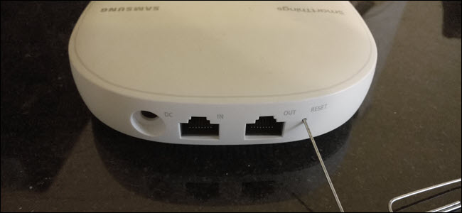 Il retro di un router wireless Samsung Smartthings con una graffetta attaccata al pulsante di ripristino.