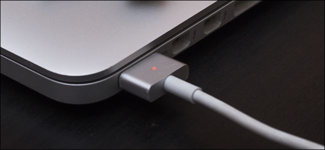 Ładowanie MacBooka z pomarańczową lampką na kablu